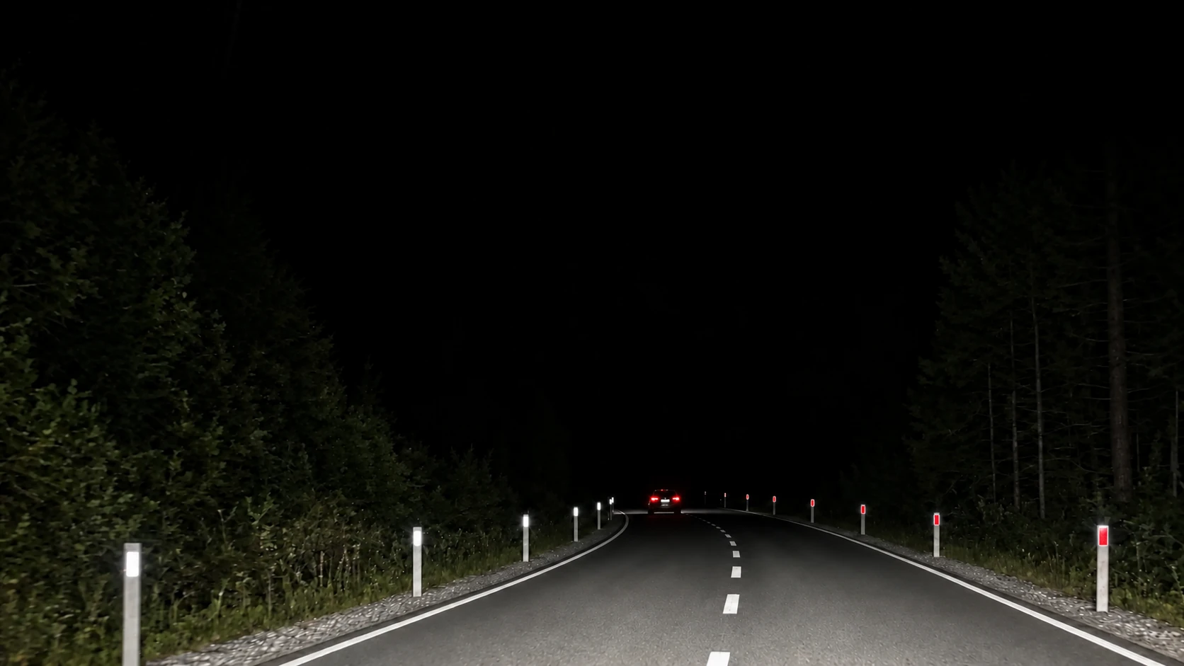 Digital application scene: a night road with roadside delineator posts and a bend warning sign